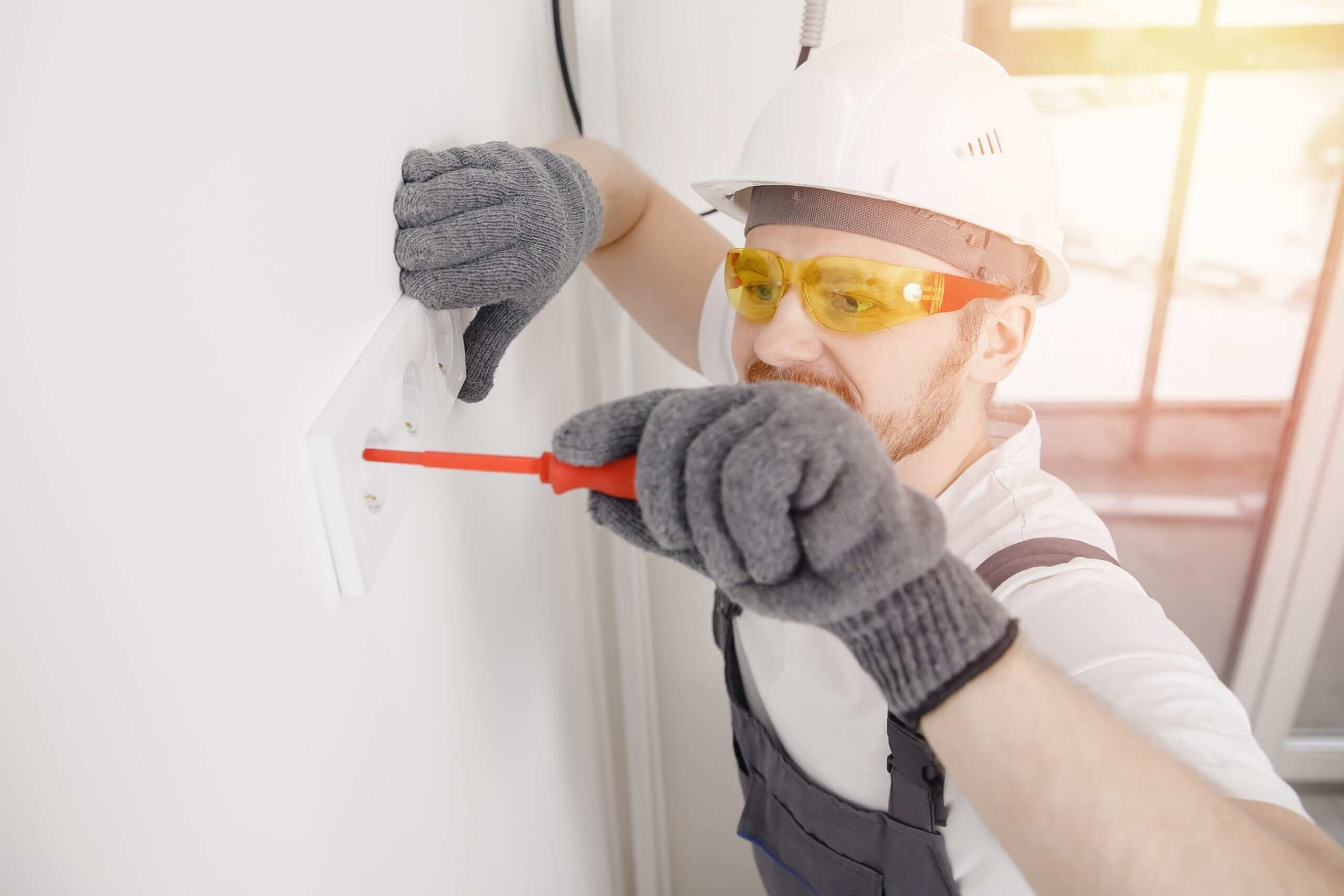 Electrician installing an outlet for a St. Louis home