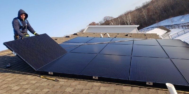 Bates Electric technician installing residential solar panels on a rooftop